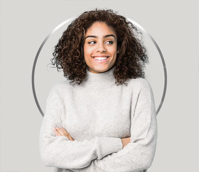 Mlada nasmejana ženska s temnimi lasmi v sivem puloverju