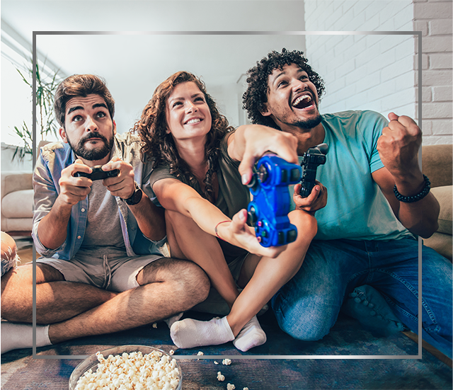 Skupina nasmejanih mladostnikov, ki sedijo na tleh in igrajo videoigre in so zadovoljni po zdravljenju glivične okužbe kože s Canesporjem