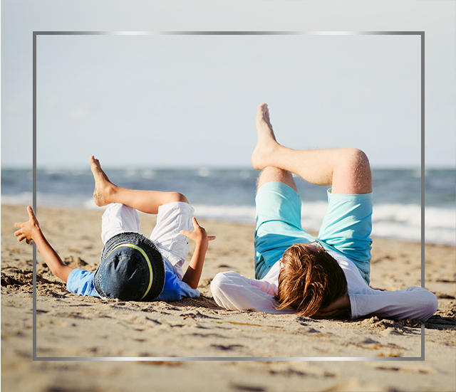 Mama in otrok ležita na plaži s prekrižanimi nogami in sta zadovoljna po zdravljenju glivične okužbe kože s Canesporjem